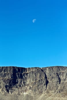 Moon on a background of blue sky and mountains Khibiny