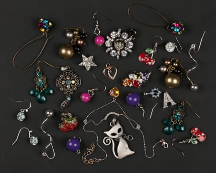 jewelery, earrings scattered on a black background