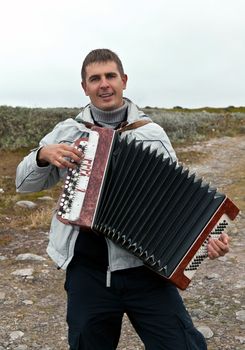 man with an accordion in the background of the Barents Sea