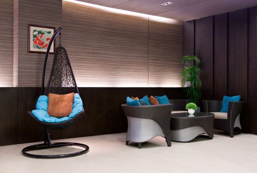chair hanging on a chain in the hotel lobby sofa with blue pillows