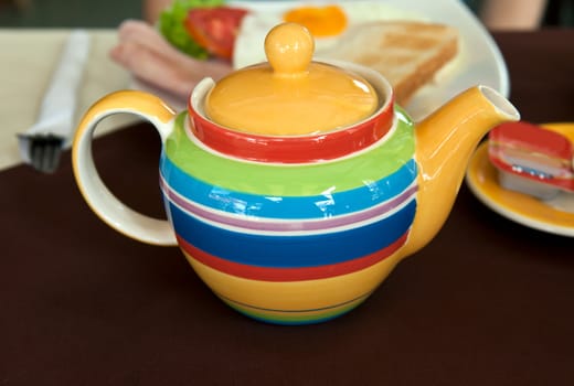 colored striped teapot on the table with breakfast
