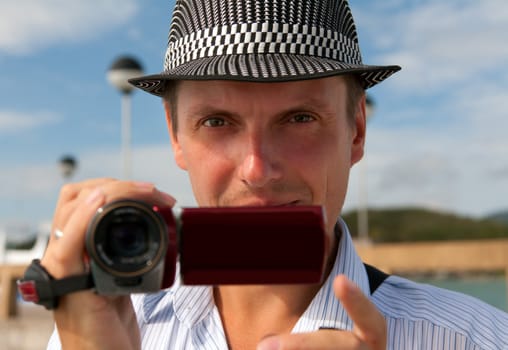 man in a hat with a camera looking to the frame