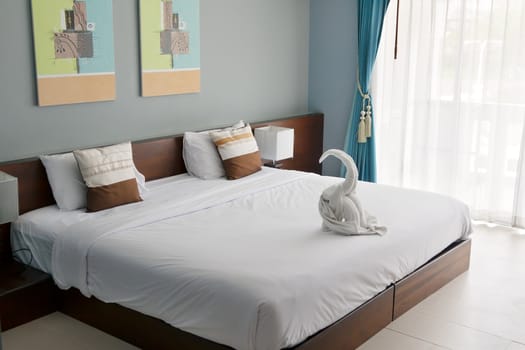 room in a hotel bed with a window and a towel