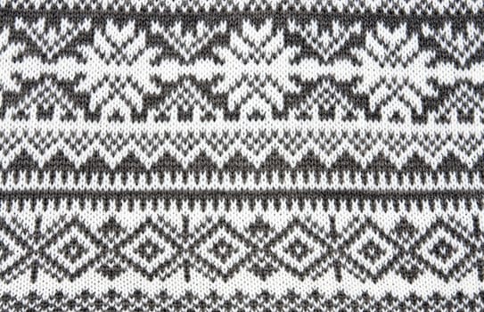 gray background with a knitted pattern to form snowflakes
