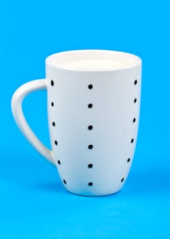 cupful of milk on blue background