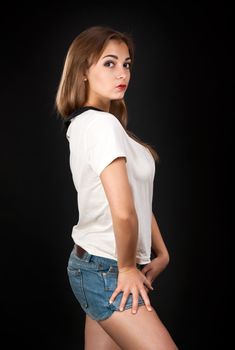 seductive girl in shorts on a black background