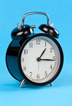 Classic alarm clock on a blue background