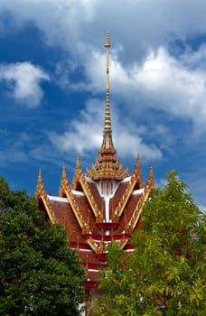 Beautiful Thai temple against the blue sky with clouds