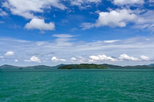 Landscape of palm island on the horizon in the Andaman Sea with blue sky and clouds