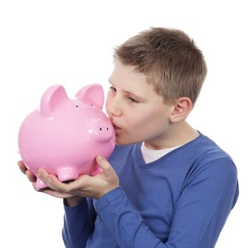 cute boy kissing pink piggybank on white background