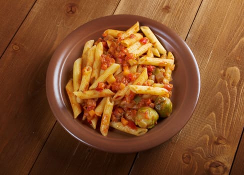 Italian Penne rigate pasta  with  vegetable  tomato sauce  on wooden table