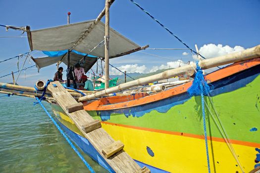 Filipino family living on their fishing boat in Subic Town, Philippine Islands. These boats are used for fishing and for local transportation. The boats are called outriggers, canoes, pump boat and bangka.