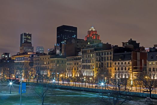 Night skyline of the Old Port section of Montreal, Canads showing skyscrapers, old architecture and colored lights.