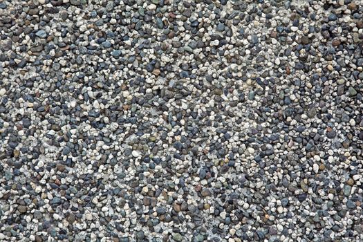 Abstract background of white, black, gray, grey, blue and brown small pebbles.