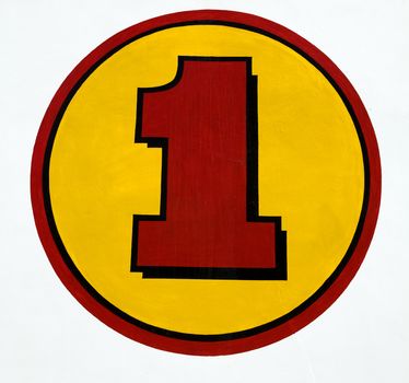 Painted red number one inside a yellow circle.