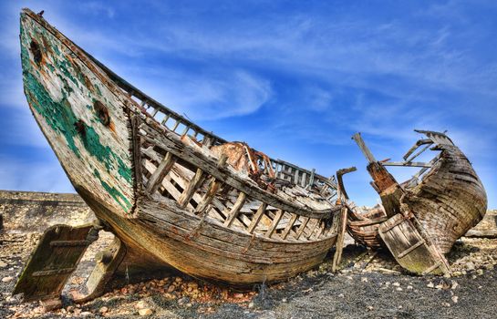 Wrecks of wooden ships on an empty shore at the Atlantic Ocean.
