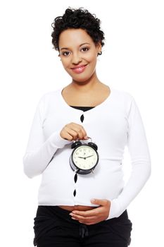 Pregnant woman holding alarm clock