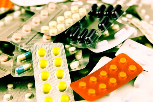 Pills of many shapes and colors grouped together.
