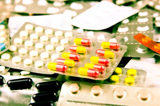 Pills of many shapes and colors grouped together.
