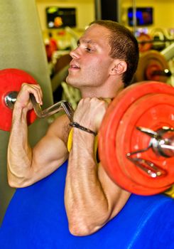 Portrait of handsome bodybuilder doing exercise in fitness club