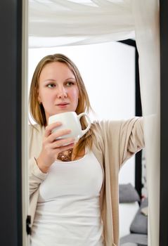 Woman drinking coffee by the balcony.