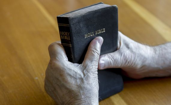 holding the bible over table