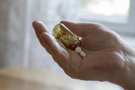 old man holding pills and he needs help