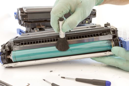 hands cleaning toner cartridge with brush the dust. worker Laser printer on a workbench. Printer workshop