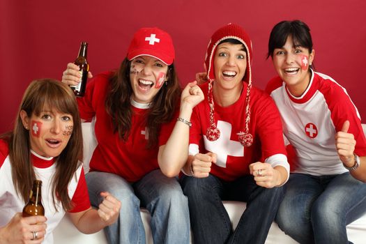 Photo of female Swiss sports fans smiling and cheering for their team.
