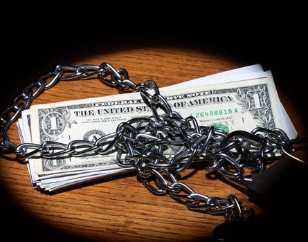 Chain and dollar bills in spot light