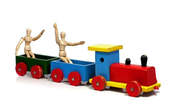 two wooden dolls sitting on a red yellow and green train