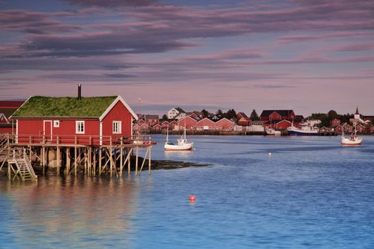 Red fishing rorbu hut by the fjord in town of Reine on Lofoten islands