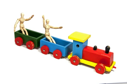 two wooden dolls sitting on a red yellow and green train