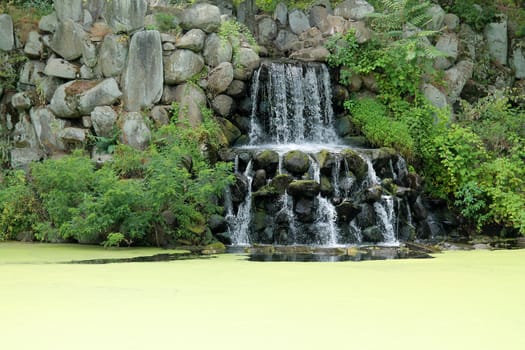 A waterfall on a algae covered pond