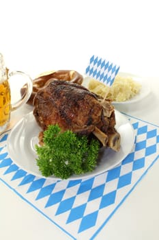 Bavarian roasted pork knuckle and pretzels with sauerkraut on a light background