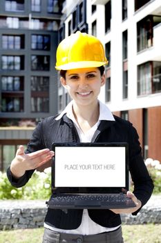 Female construction engineer show something on laptop