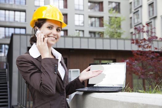 Female construction engineer show something on laptop