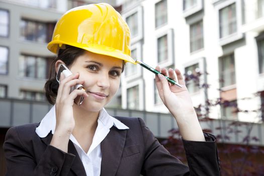 Young female construction engineer with phone