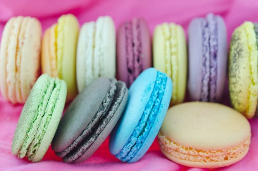 close up colorful  french macaroons   on  pink fabric
