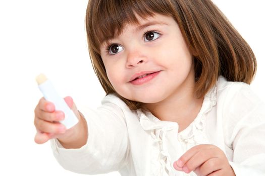 Portrait of cute little girl with lip balm. Isolated on white background.