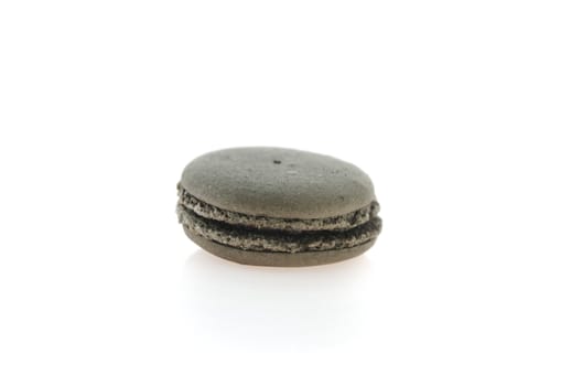 black  french macaroons over white background . single  dessert