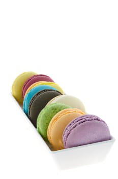 close up colorful  french macaroons in bowl on white background