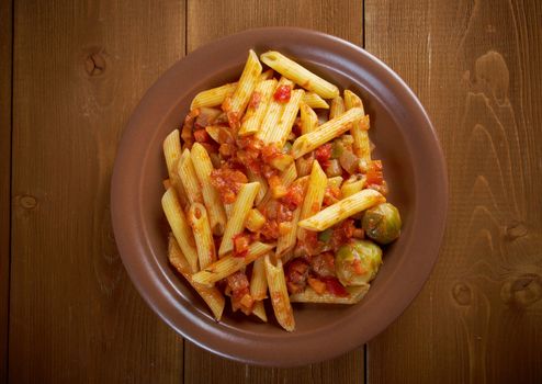 Italian Penne rigate pasta  with  vegetable  tomato sauce  on wooden table