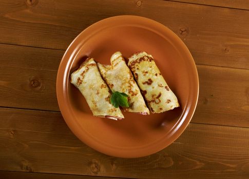 rolled pancakes stuffed ham and cheese. Shallow depth-of-field.