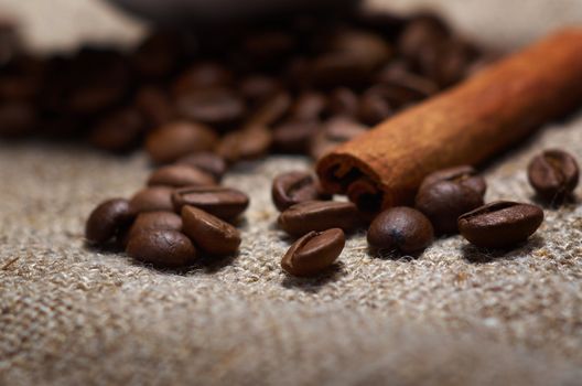 Coffee cup with cinnamon and coffee beans background