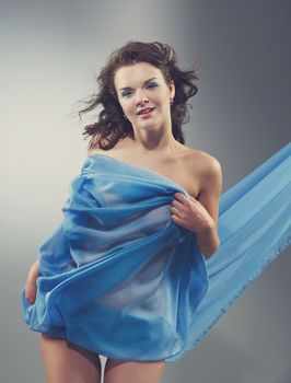 Beautiful woman in  waving fabric.Portrait of young dancing girl