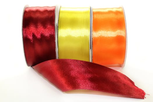 three rolls of ribbon in front of white background