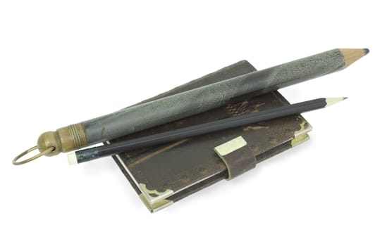 Ancient and modern pencils with the book for notes  are isolated on the white
