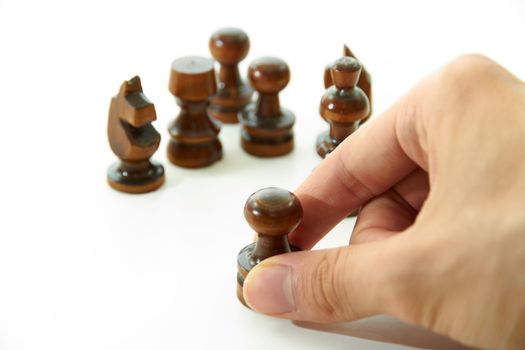 Chess pieces are holding by hand on white background