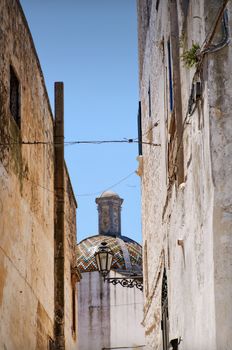 Ostuni lane in the Old Town (the White City) with a dome in the background, Puglia, Italy